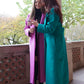 Zwei junge Frauen, die einen grünen und einen rosa langenMantel von Lola Tong tragen. .