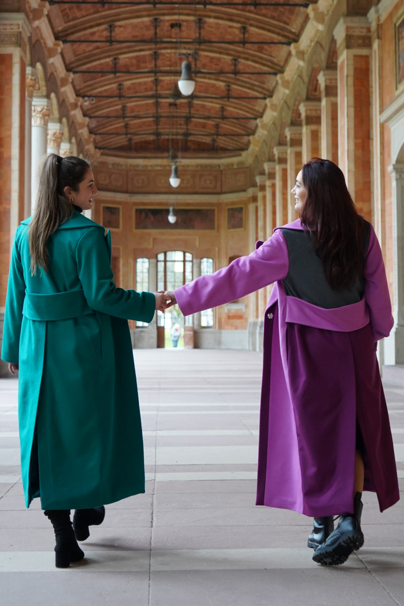 Zwei Schwestern, die einen grünen und einen rosa langen Mantel von der Slow Fashion Brand Lola Tong tragen.